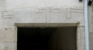 Rue de la Libration, linteau de porte dcor d'une croix entoure d'une serpette et d'un outil taillant (JPG)